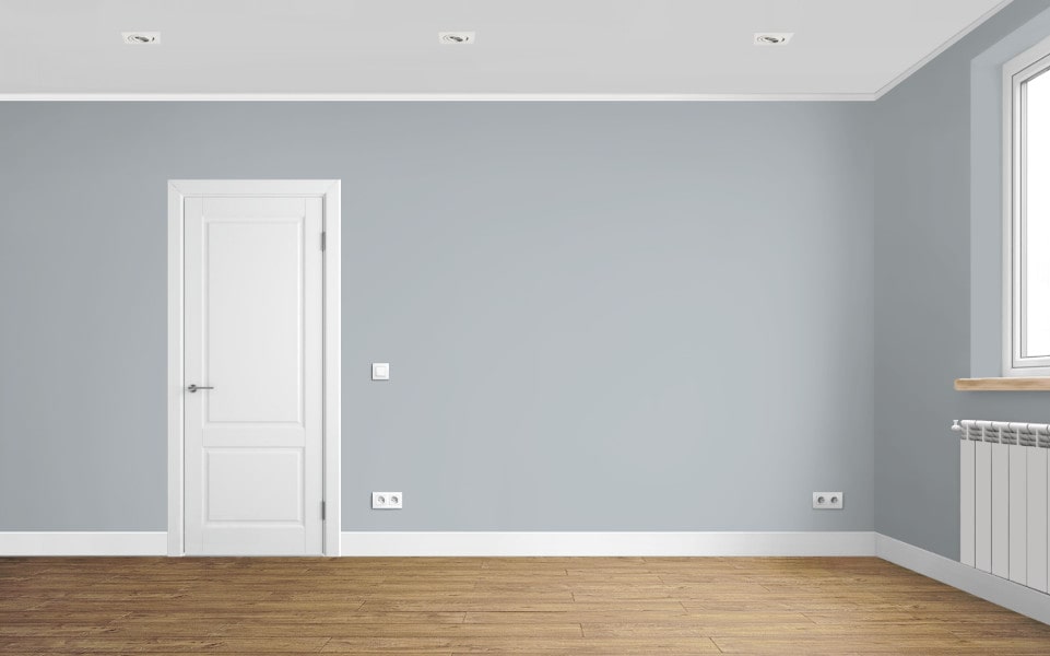 Интерьер с серыми стенами, белыми плинтусами, белой филёнчатой дверью и ламинатом Quick-Step Impressive Дуб Деревенский.