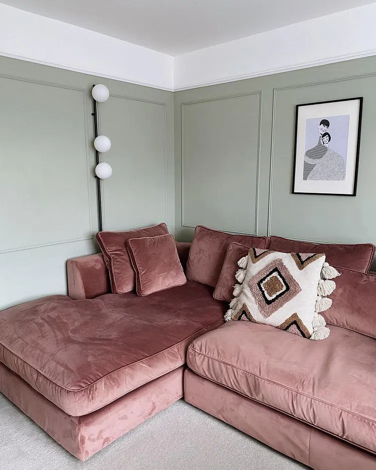 Интерьер гостиной с розовым бархатным диваном и серыми стенами
