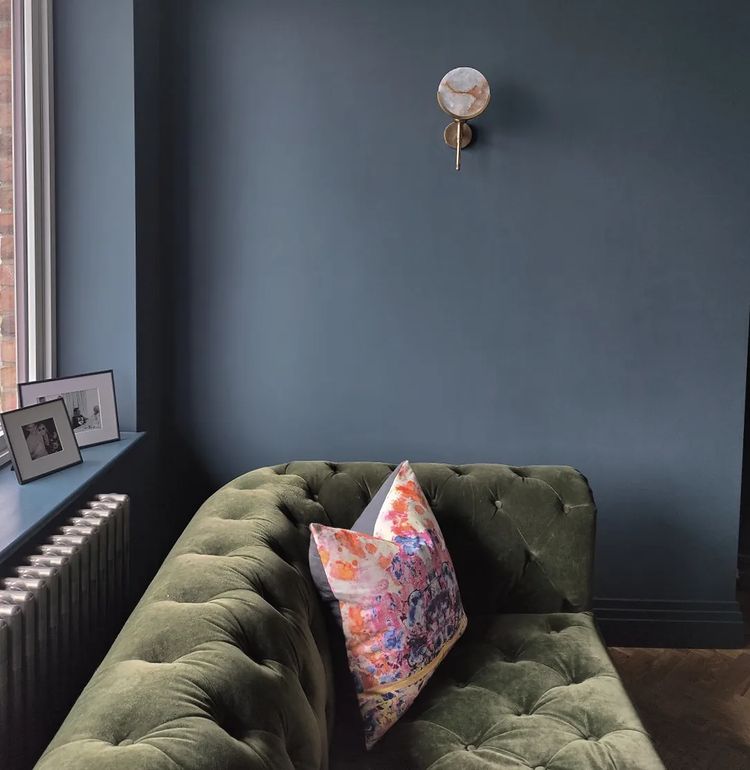 Стильный интерьер с синими стенами и зеленым диваном