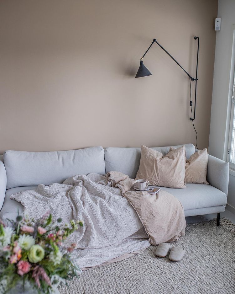 Акцентная бежевая стена и белый диван в интерьере