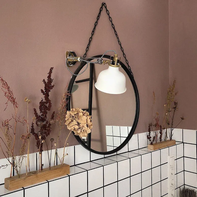 Круглое зеркало с черной рамой в ванной